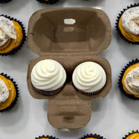 a natural paper pulp 2-cell egg carton with two mini cupcakes in it.