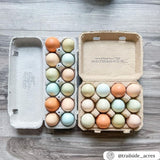 A stamped blank paper pulp 12-egg carton next to a 12-egg vintage carton filled with eggs