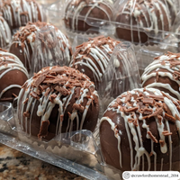 Hot chocolate bombs in a clear plastic carton typically used for 6 goose eggs.