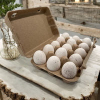 A 15-egg natural paper pulp unprinted quail egg carton with 15 speckled eggs inside. Background is rustic farmhouse decor
